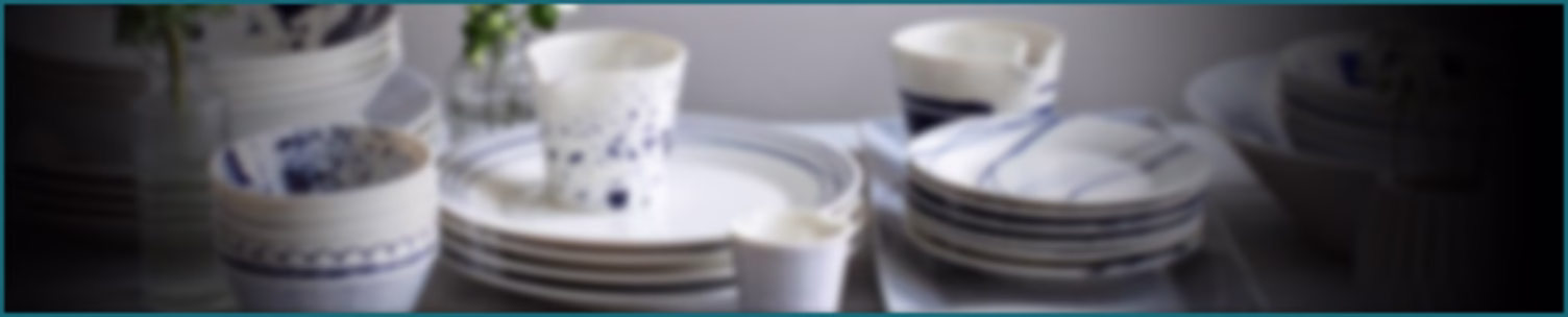 Slightly blurred and slim image of various Royal Doulton blue designer patterned teacups, saucers, plates, jug and bowl.